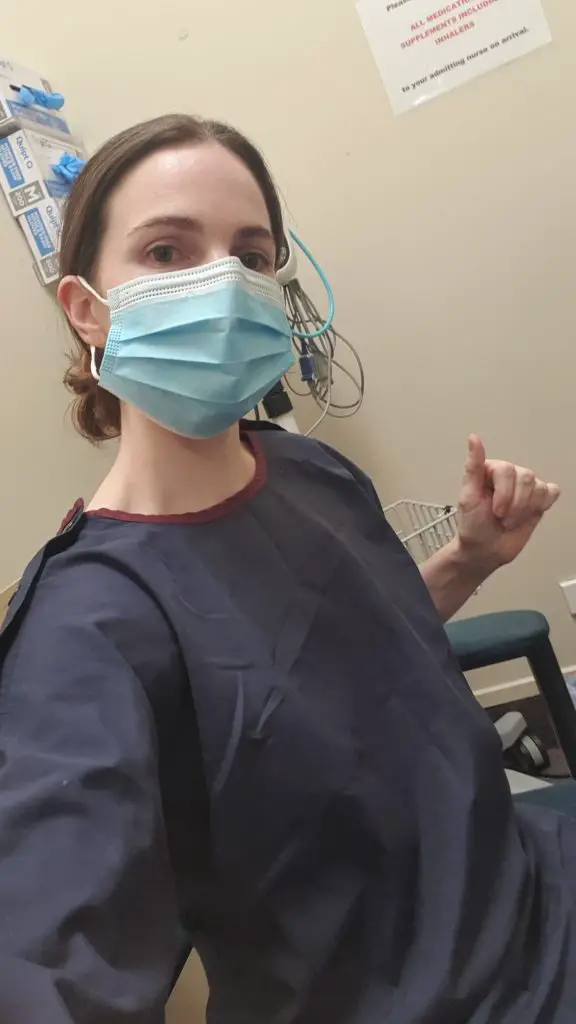 Melissa in a mask and hospital gown