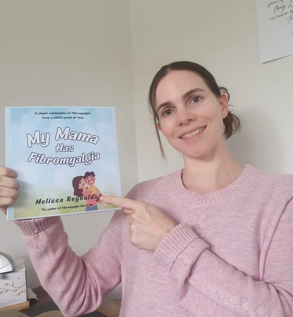 Melissa holding a copy of her book My Mama Has Fibromyalgia